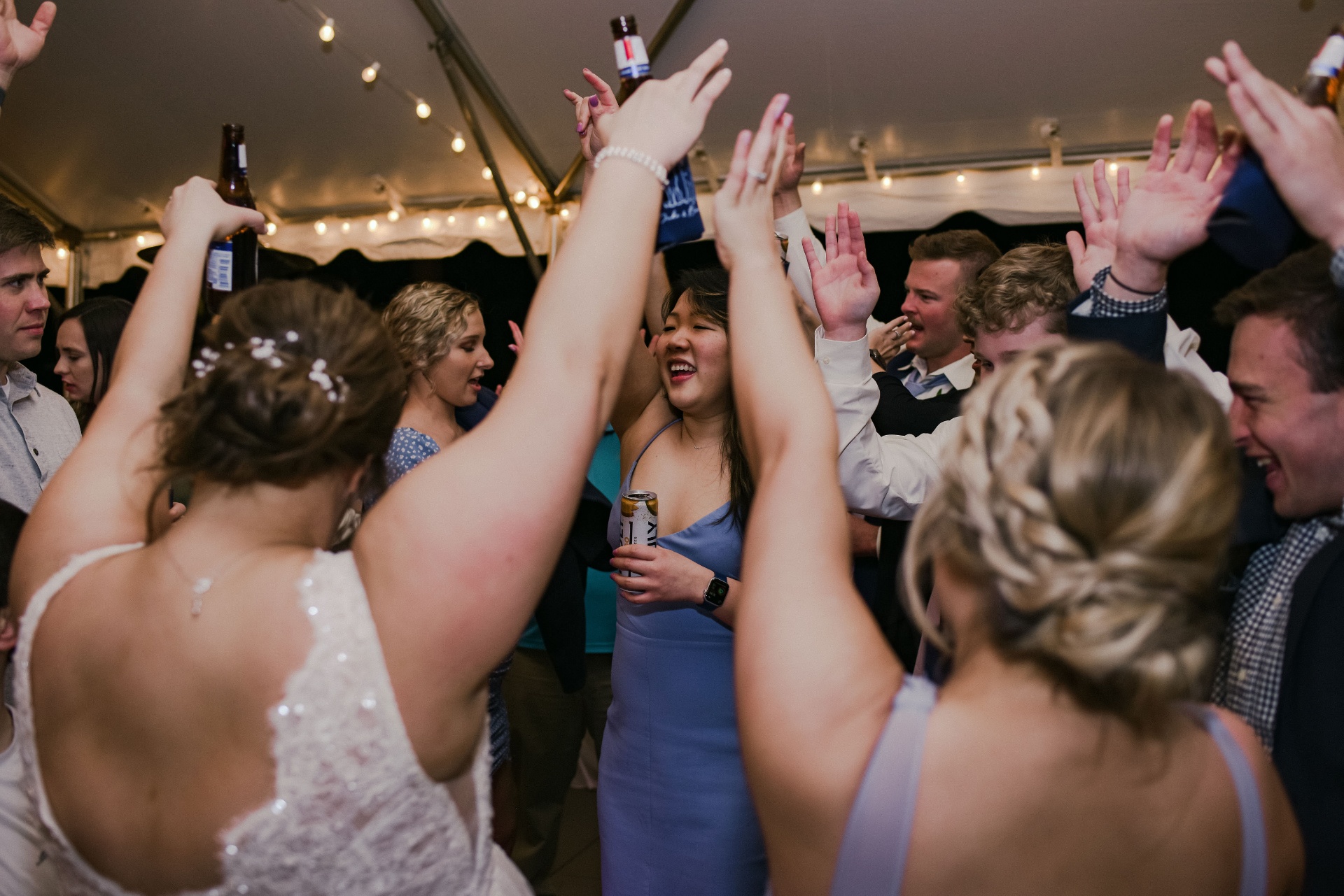 Wedding guests cheering with hands in the air on the dance floor